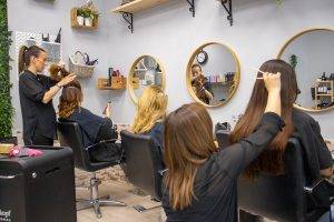 Salón de peluquería profesional con clientas, ubicado en Embajadores Madrid.